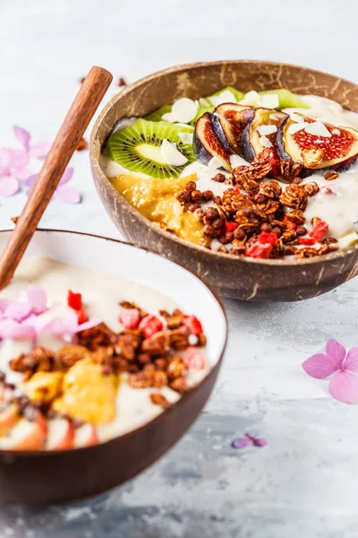 Smoothie bowl with fruit and granola with coconut shell bowl