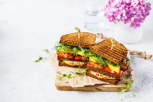 Tofu, humus, avokado, domates ve lahana ile vegan sandviç.