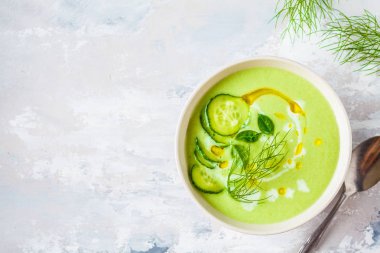 Gri arka planda beyaz kapta Vegan soğuk salatalık krema çorbası
