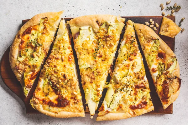 Vegetarian pizza with zucchini, cheese and nuts.