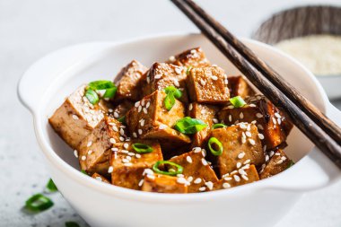 Susamlı kızarmış tofu ve beyaz kasede yeşil soğan..