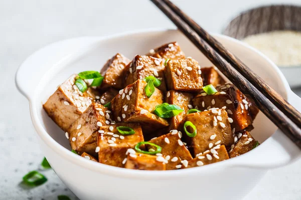 Susamlı kızarmış tofu ve beyaz kasede yeşil soğan..