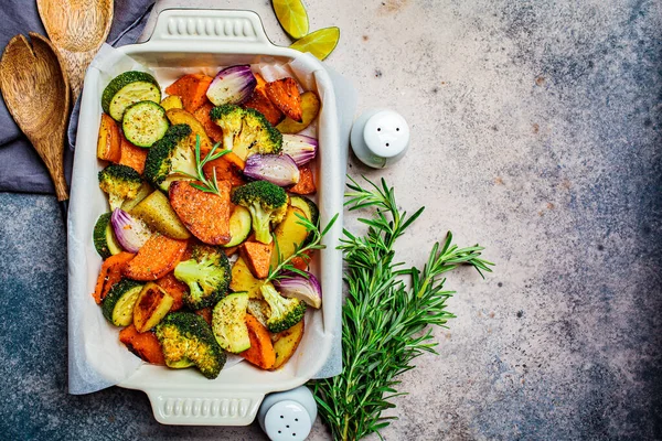 Baked vegetables in the oven dish. Baked sweet potato, zucchini and broccoli. Healthy vegan food concept.