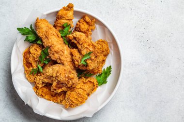 Crispy fried chicken in a white bowl, top view. clipart