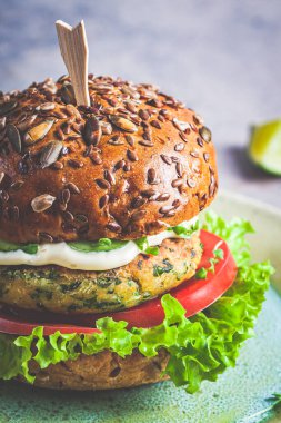 Sebzeli ve soslu vejetaryen falafel burger, koyu arkaplan. Sağlıklı gıda konsepti.