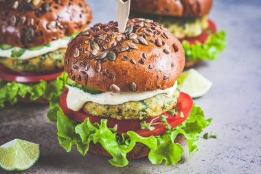 Sebzeli ve soslu vejetaryen falafel burger, koyu arkaplan. Sağlıklı gıda konsepti.