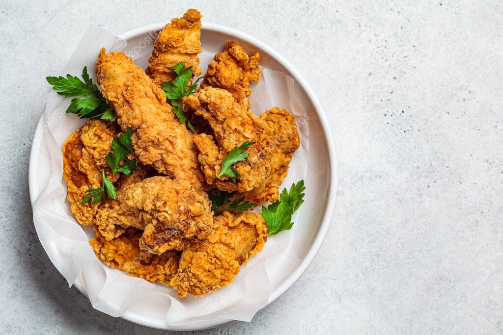 Crispy fried chicken in a white bowl, top view.