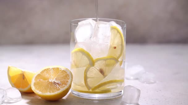 Nalijte domácí limonádu s citronovými plátky a ledem do sklenice. — Stock video