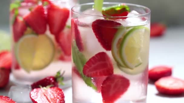Detox sassy water met aardbeien en limoen in glazen. Gezond eten concept. — Stockvideo