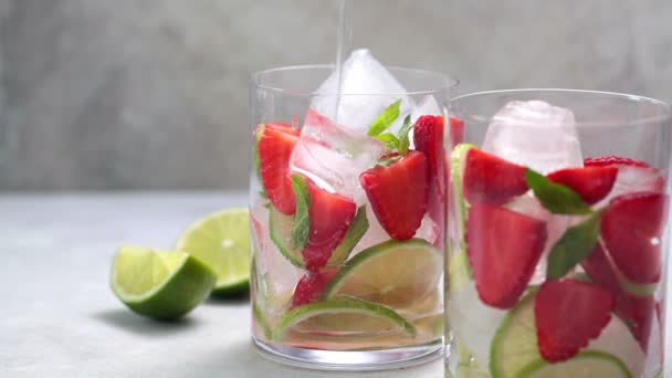 Detox sassy water met aardbeien en limoen in glazen. Gezond eten concept. — Stockvideo