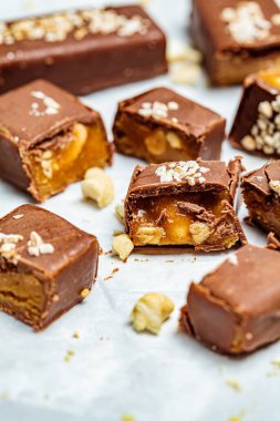 Çiğ vejetaryen çikolatası, karamel barlar, beyaz arka plan. Sağlıklı tatlılar konsepti.