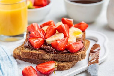 Kahvaltıda çikolata, muz ve çilekli tost..