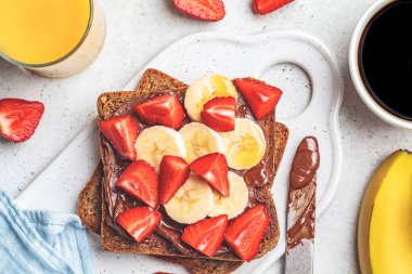 Kahvaltıda çikolatalı tost, muz ve çilekli sandviç..