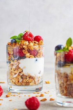 Granola, ahududu ve böğürtlenli yoğurt, açık arkaplan. Sağlıklı kahvaltı kavramı.