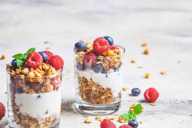 Granola, ahududu ve böğürtlenli yoğurt, açık arkaplan. Sağlıklı kahvaltı kavramı.