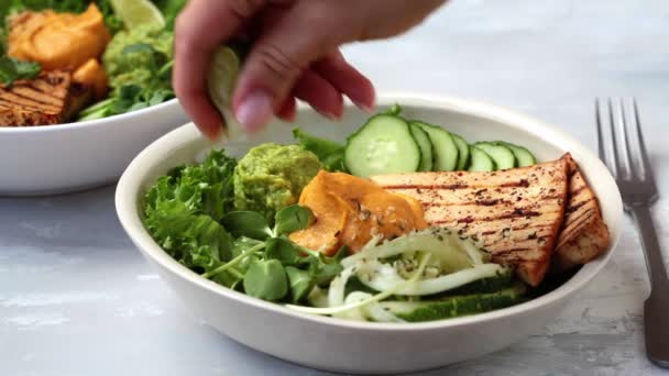 Déjeuner végétalien - bol de bouddha avec pâtes de courgettes, tofu grillé, guacamole, houmous de patates douces et légumes. — Video