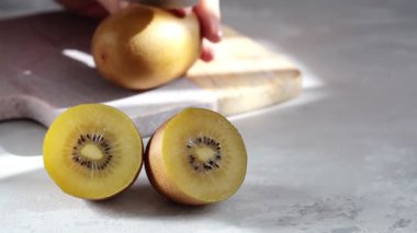 Gri arka planda olgun dilimlenmiş sarı kivi yarıları