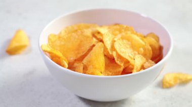 Elleri beyaz kasede patates cipsi yemek. Fast food konsepti.