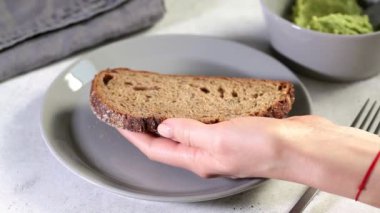 Çavdar ekmeğine Guacamole. Avokado tostu gri tabakta.