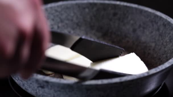 Friterad halloumi ost i en grå stekpanna. Stekt ost i kastrull, närbild. — Stockvideo