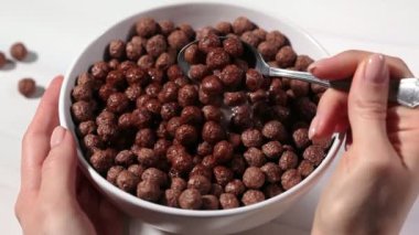 Çikolata topları, beyaz arka planda sütlü mısır gevreği. Kahvaltı konsepti..