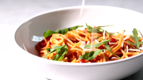 Nahaufnahme von Nudeln mit Tomatensauce, Käse und Rucola in einer weißen Schüssel — Stockvideo