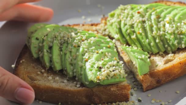 Toast all'avocado con semi di canapa su un piatto. — Video Stock