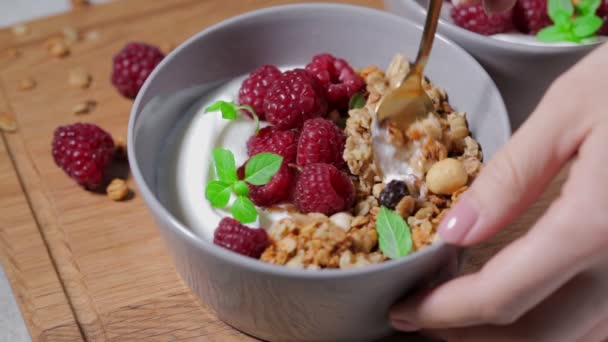Śniadanie musli z jogurtem i malinami w misce. — Wideo stockowe