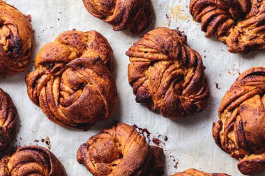 Kakule ve tarçınlı İsveç çörekleri, hafif arka plan. İskandinav mutfağı konsepti.