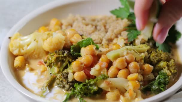 Vegansk kikärtcurry med blomkål, broccoli, grönkål och quinoa. — Stockvideo