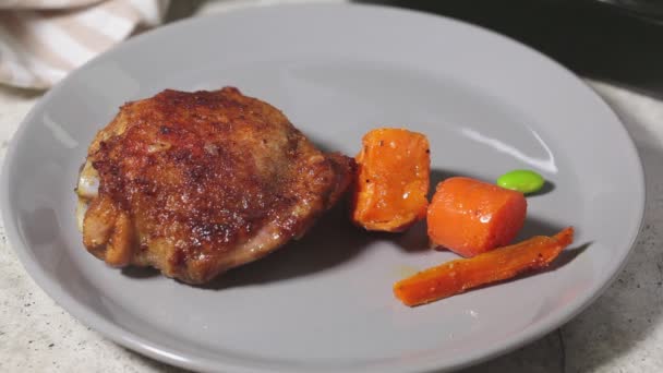 Hände legen gebackenes Hühnchen und Gemüse auf einen Teller. Konzept für gesunde Ernährung. — Stockvideo