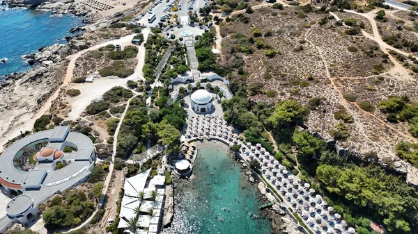 Yunanistan 'ın Rhodes Island kentindeki Kallithea Springs' in çarpıcı insansız hava aracı görüntüsü, tarihi spa kompleksi, güzel turkuaz körfezi, sıra sıra saman şemsiyeler ve güneş panzeleriyle kumlu plajı ve kristal berrak Akdeniz suyunu gözler önüne seriyor. Yolculuk için mükemmel.