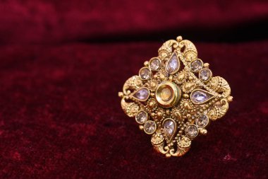 Süslü değerli mücevher tasarımcısı altın yüzük closeup makro görüntü kadın için kırmızı zemin üzerine