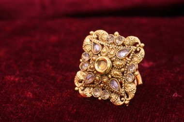 Süslü değerli mücevher tasarımcısı altın yüzük closeup makro görüntü kadın için kırmızı zemin üzerine