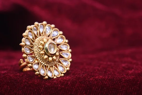 花式设计师珍贵的珠宝金色戒指特写镜头宏观图像在红色背景上的女人 — 图库照片