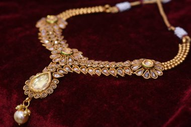 Tasarımcı güzel altın kolye closeup makro görüntü kırmızı zemin üzerine.