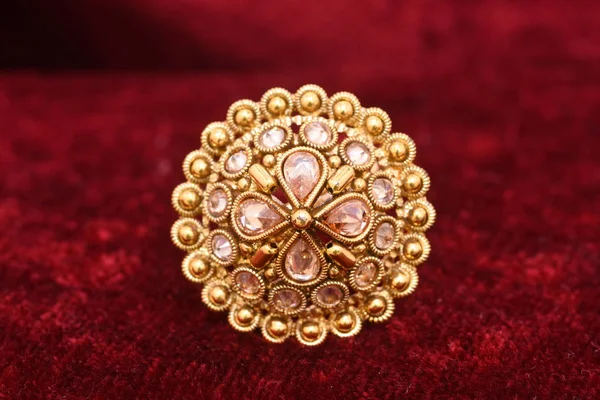 Fancy designer precious jewelry golden ring closeup macro image on red background for woman