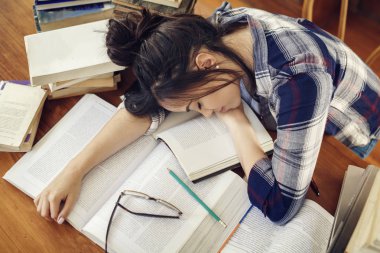Kağıt kitaplara uyku İspanyol kadın öğrenci yorgun eğitim, sınavlar için hazırlanıyor