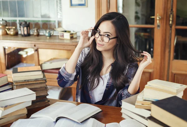 Gözlük ile kameraya bakarak, Kütüphanesi'nde çalışma eğitim kağıt kitap çok güzel İspanyol kadın