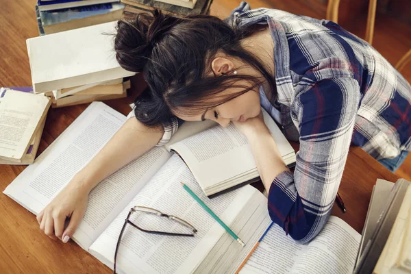 Kağıt kitaplara uyku İspanyol kadın öğrenci yorgun eğitim, sınavlar için hazırlanıyor
