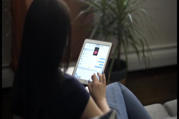 Young woman using her tablet for texting — Stock Video