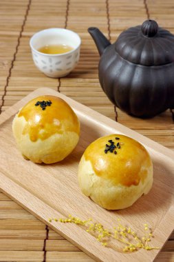 Salted Egg Yolk Pastry (Egg Yolk Crisp) on wooden plate. Yolk Pastry is a popular mooncake in Taiwan. Concept for Mid-Autumn Festival or Moon Festival.
