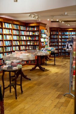 Saffron Walden, Essex, İngiltere - 25 Ocak 2024: Ahşap döşeme ve kurgu ve seyahat kitaplarının sergilendiği bir kitapçının içi