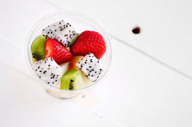 Beyaz arka plan üzerinde meyve ile plastik bardak