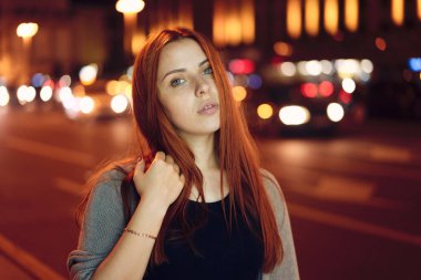 Kızıl saçlı kız gece şehrin arka plan üzerinde