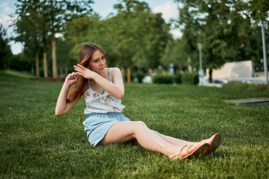 Çim Bisiklet yanında oturan ve bir dinlenme pretty genç kız