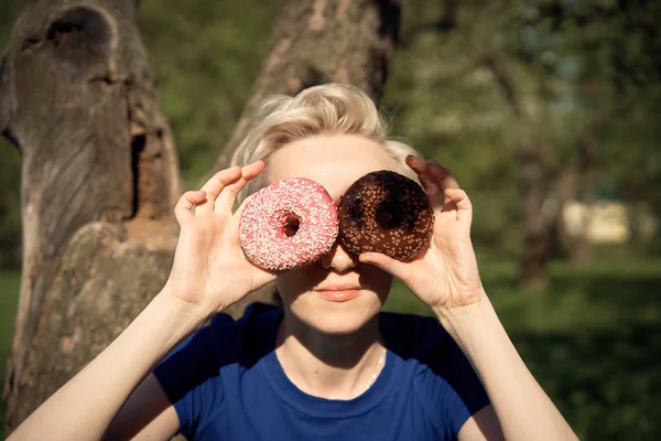 Девушка с пончиком в парке — стоковое фото