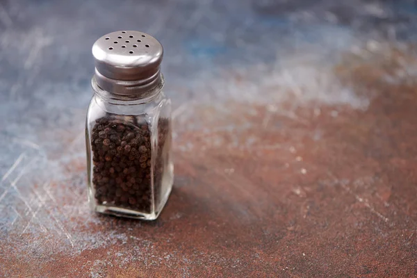 Pimienta negra en las cocteleras de pimienta sobre fondo oscuro — Foto de Stock