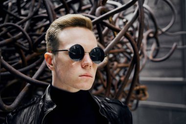 paslı demir arka plan üzerinde güneş gözlüğü yakışıklı bir genç adam portresi