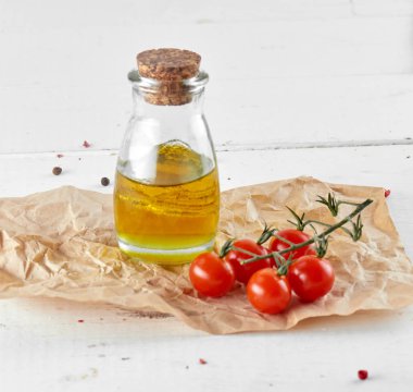 Beyaz ahşap zemin üzerinde petrol şişe ile domates